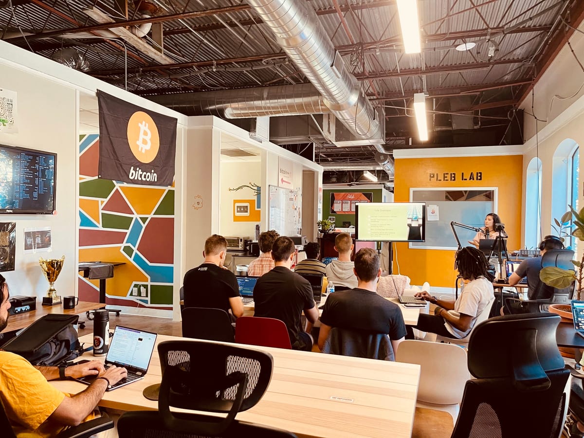 Builders at laptops during a hands-on AI and Bitcoin workshop