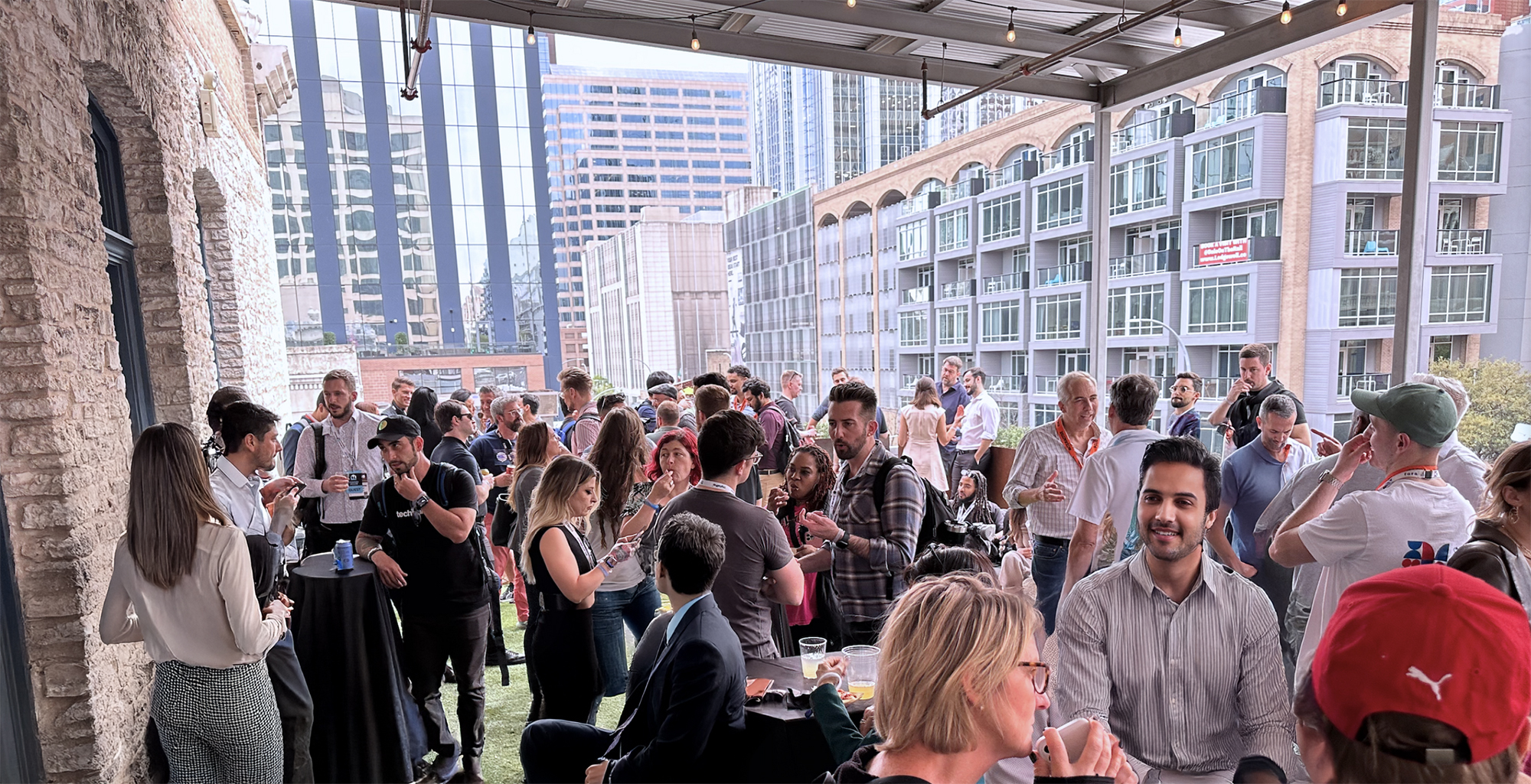 Builders networking at a packed Q Branch rooftop event